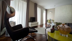 A modern living room with a black chair, a white entertainment unit, and a yellow side table. - Cardosas Story Apart byPortoCityHosts (Porto)