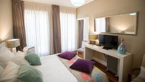A hotel room with a bed, a desk with a TV, a lamp, and a vase. - Cardosas Story Apart byPortoCityHosts (Porto)