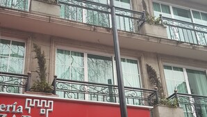 Een meerlaags gebouw met balkons, een rode luifel met de tekst 'ZAR' erop en een lantaarnpaal.