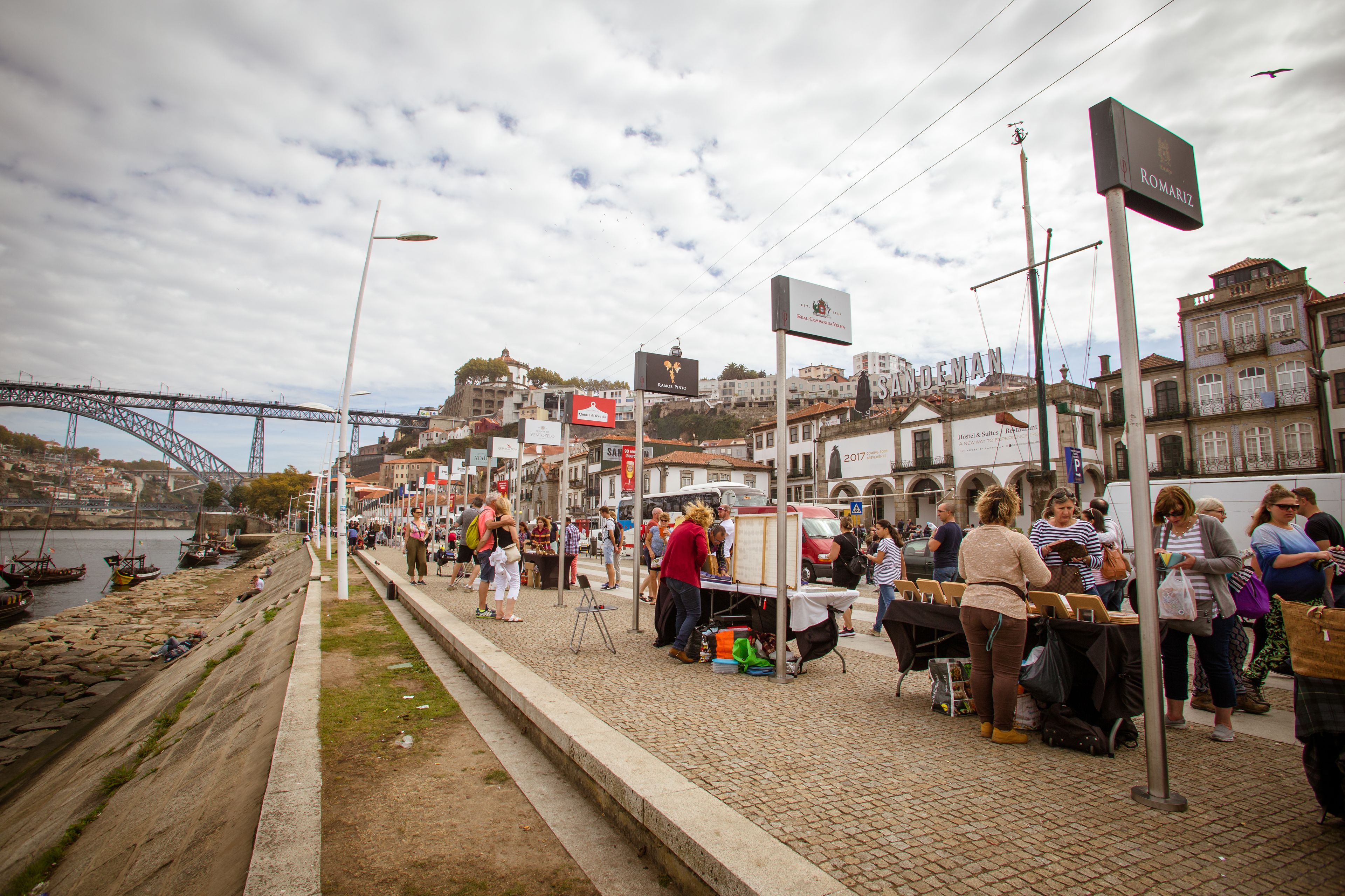 Mercado a la orilla del río con puestos y gente.