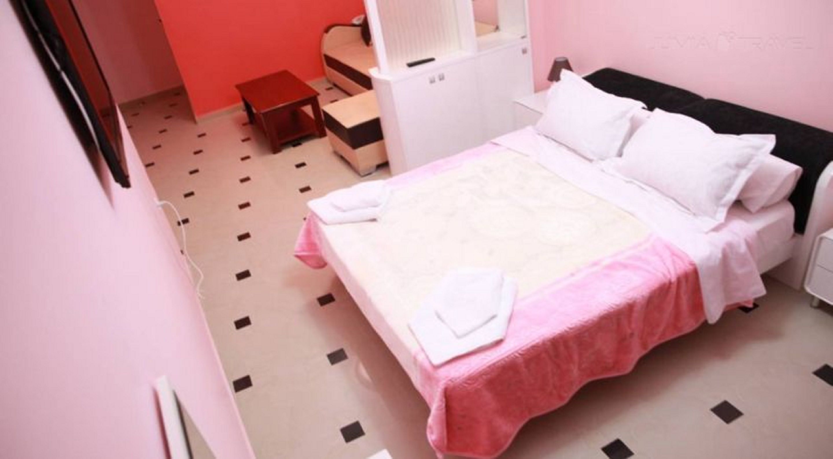 A bedroom with a bed, a nightstand, a chair, and a small table.