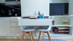 A modern kitchen with a white countertop, a coffee maker, and a wine bottle. - Almada Story Apartments by Porto City Hosts (Porto)