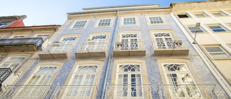 A building with multiple balconies, large windows, and a tiled facade.