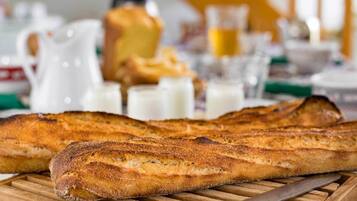 Ein Holzschnittbrett mit einem Baguette und einem Messer.