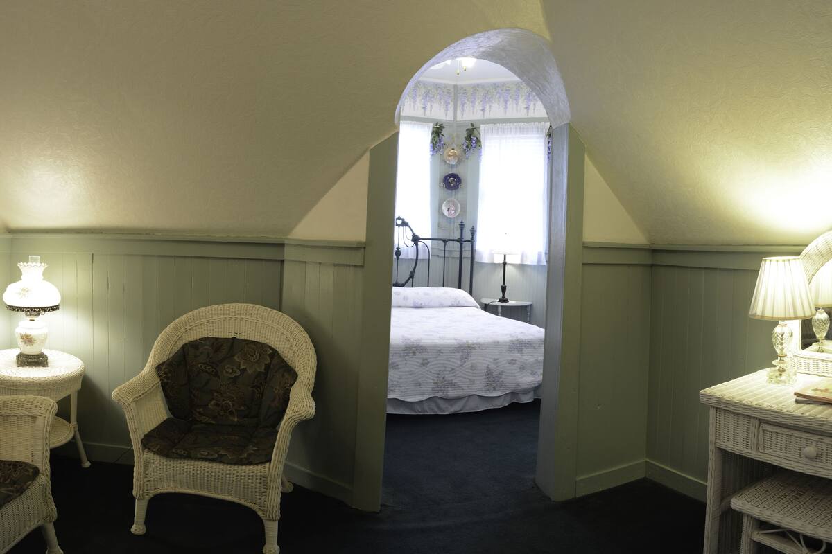 Une chambre à coucher avec un lit, une chaise et une lampe.