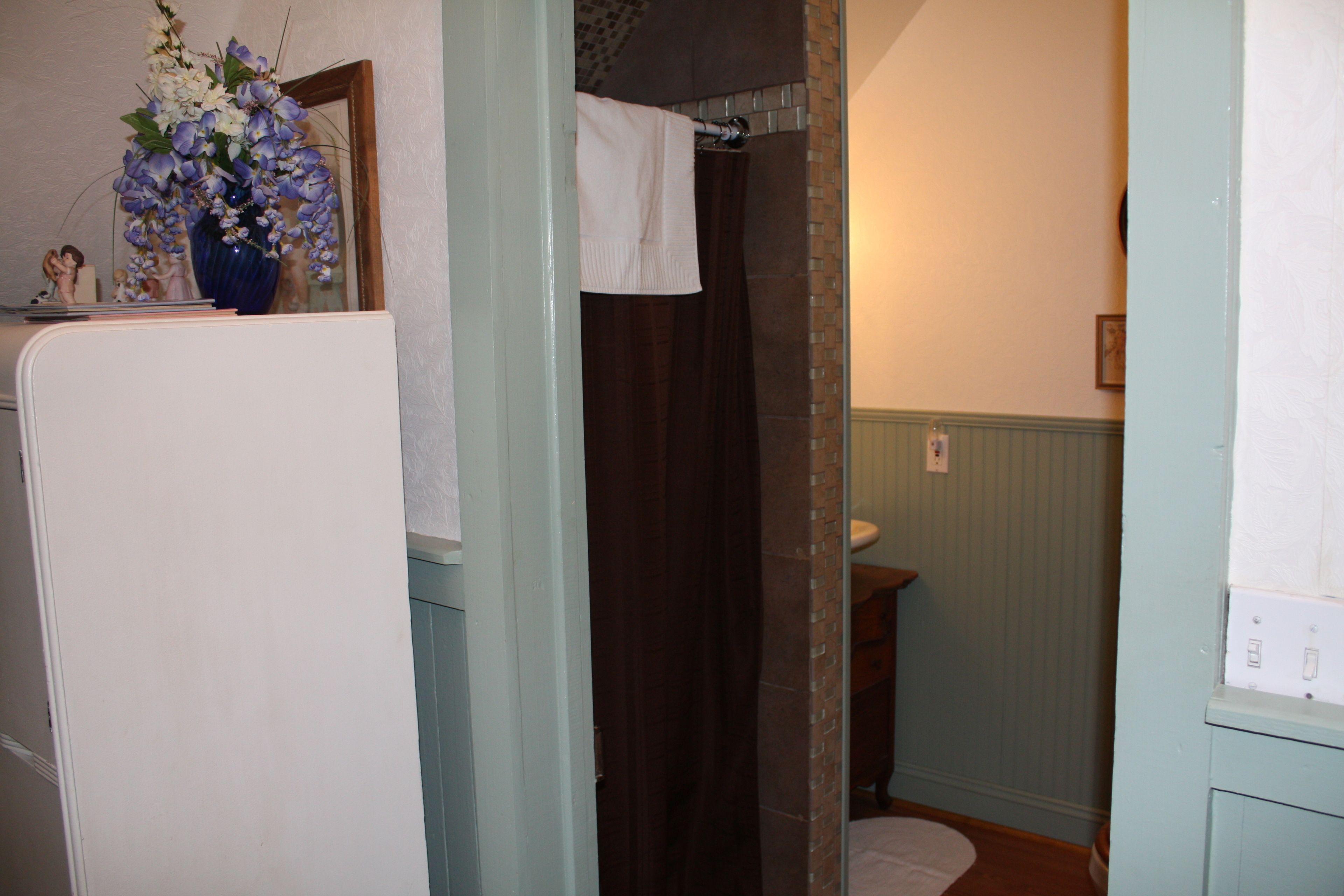 A bathroom with a shower, a sink, and a mirror.