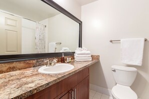 A bathroom with a sink, mirror, toilet, and towel rack.