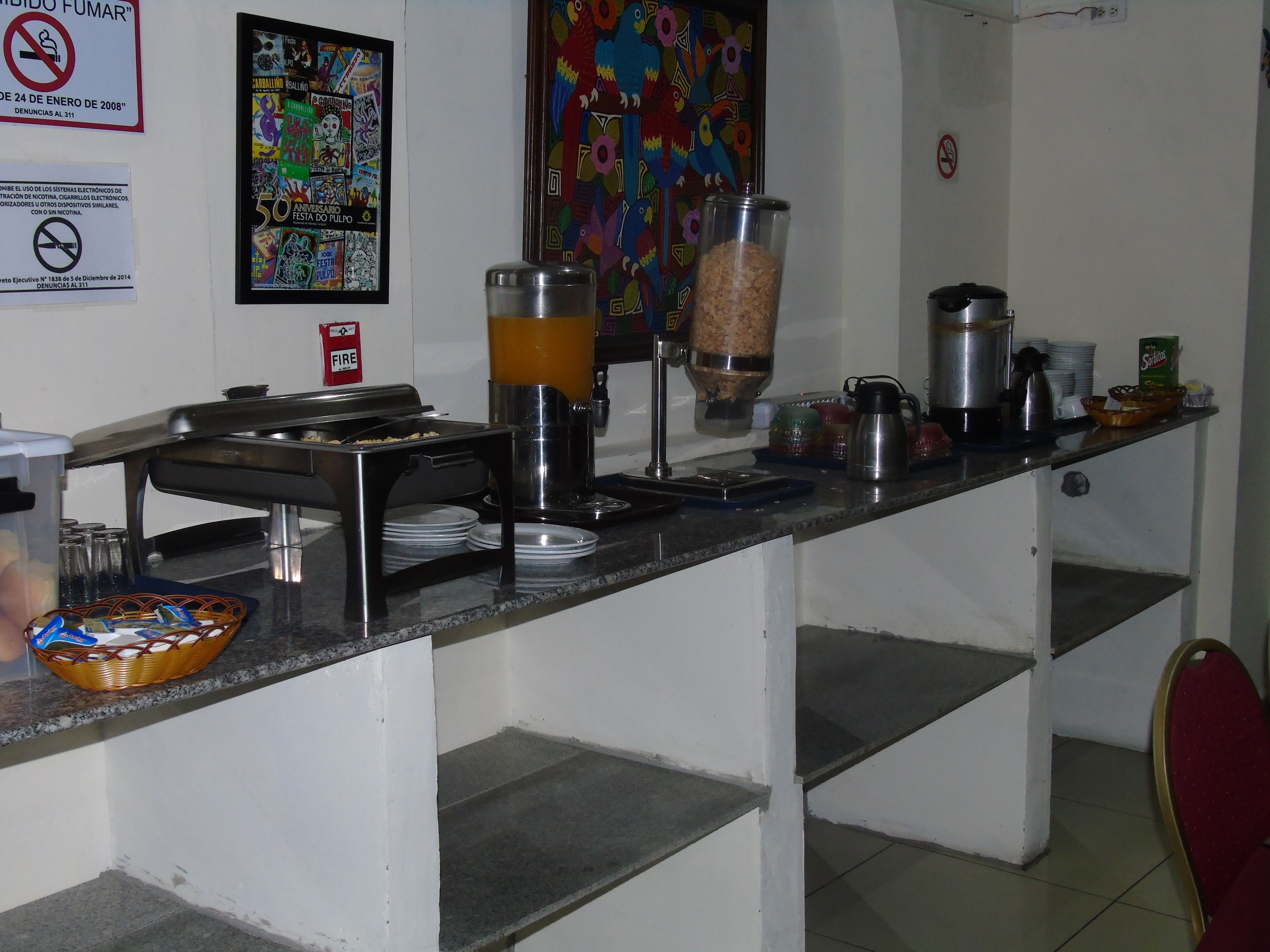 A buffet setup with a coffee maker, a food dispenser, and various dishes.