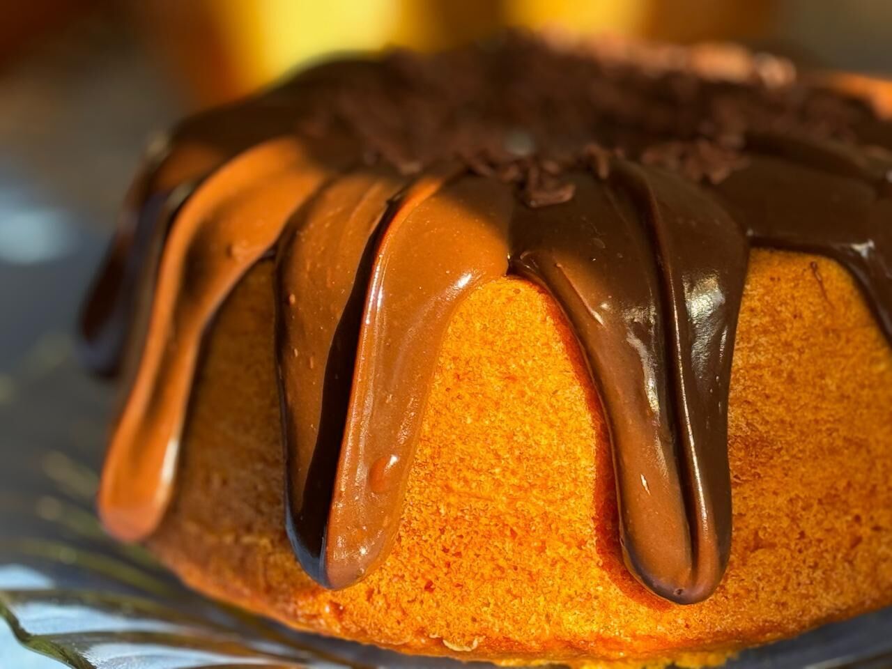 Un gâteau en forme de couronne, nappé d’un glaçage au chocolat, présenté sur une assiette.