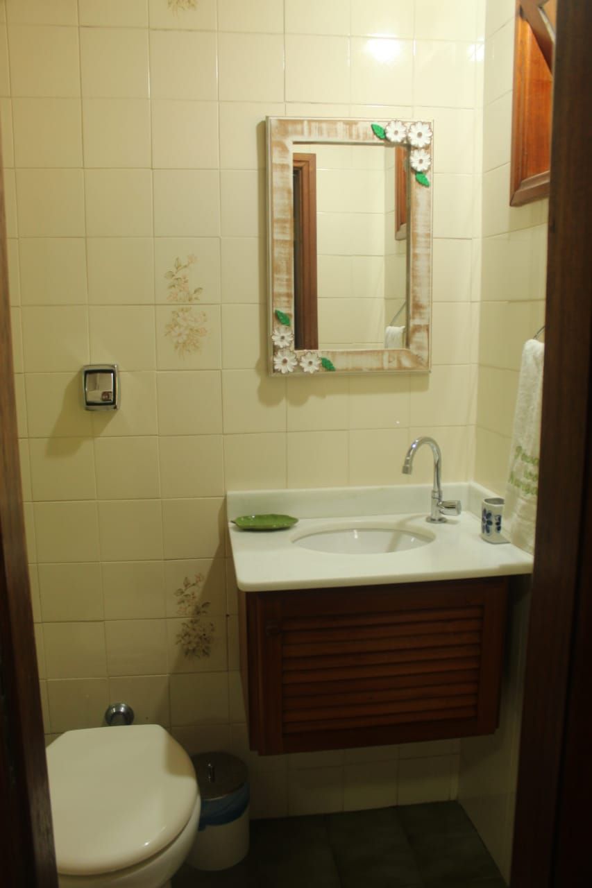 A small bathroom with a toilet, sink, and mirror.