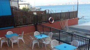 Une terrasse avec des places assises extérieures et une vue sur la mer.