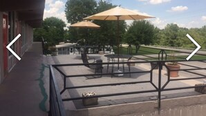 An outdoor patio area with tables and chairs, umbrellas, and potted plants. - The Resort (Falls of Rough)