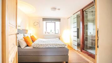 Ein Schlafzimmer mit Bett, Fenster, Heizkörper und Kleiderschrank.