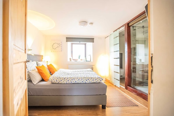 Un dormitorio con cama, ventana, radiador y armario.