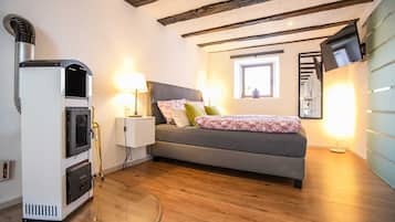Un dormitorio con cama, lámparas de noche, un calentador y televisor.