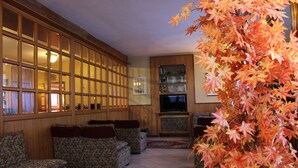Sala de estar com uma janela grande, televisão e estante de livros.