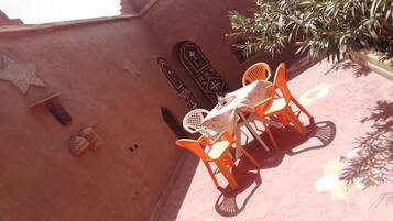 Un patio con una mesa y sillas, una estrella decorativa y una pared con diseños geométricos.