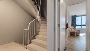 A modern interior with a staircase, a sofa, and a view of the outside. - Downtown Porto Spot - 2 (Porto)
