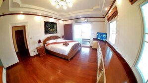 A bedroom with a wooden bed, a nightstand, a painting, and a television.