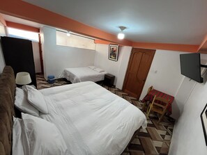 A room with two beds, a TV, a door, and a window. - Hostal Apu Qhawarina (Ollantaytambo)