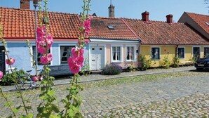A row of traditional European-style houses with red-tiled roofs and cobblestone streets. - Tastecelebration Residence (Brosarp)