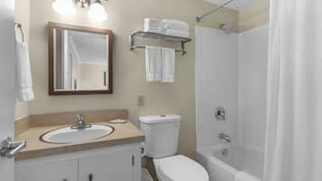 Un baño con lavabo, espejo, inodoro y bañera.