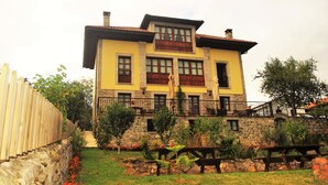 Un bâtiment à deux étages, doté d’une façade en pierre, de nombreuses fenêtres et d’un balcon avec une balustrade.