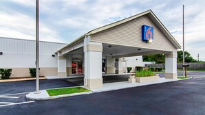 A motel with a covered entrance, a Coca-Cola advertisement, and a '6' sign. - Motel 6 Bay Minette, AL (Bay Minette)