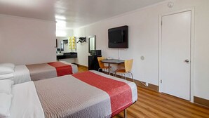 A hotel room with two beds, a small desk with a chair, a television, and a door. - Motel 6 Bay Minette, AL (Bay Minette)