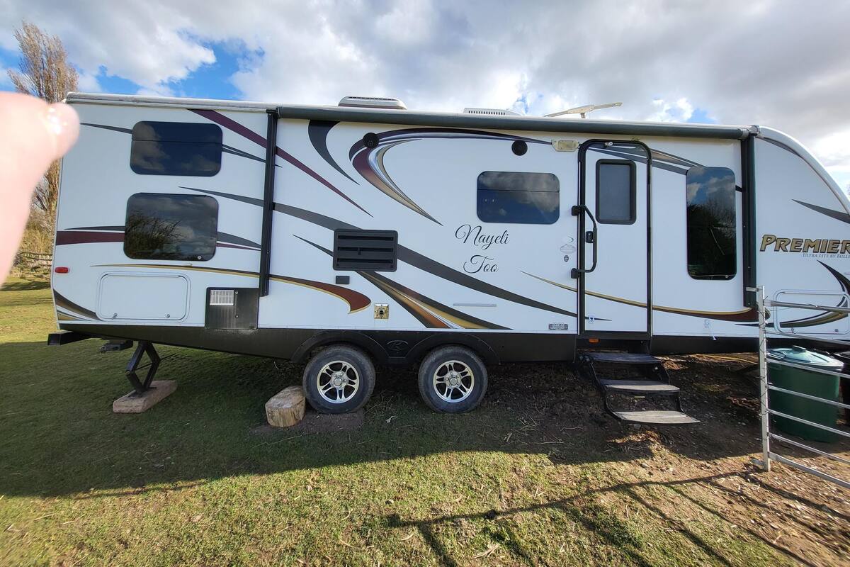 A recreational vehicle with a sliding door, a small window, and a solar panel on the roof.