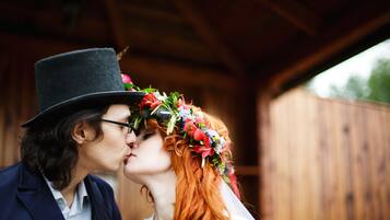 A couple embracing under a wooden structure.