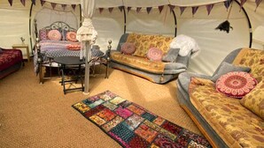 Uma tenda com uma cama, um sofá e uma mesa.