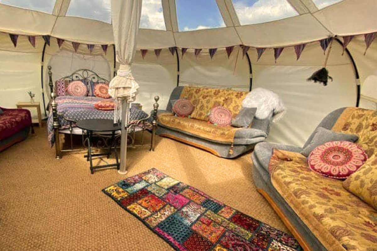 A tent with a bed, a sofa, and a table.