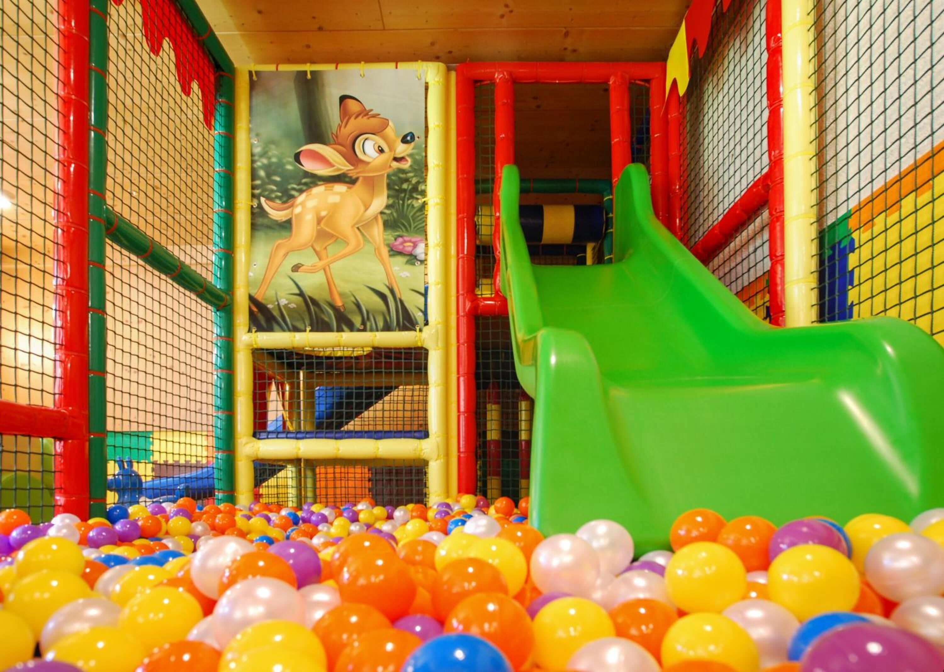 Un'area giochi per bambini con uno scivolo e una piscina di palline.