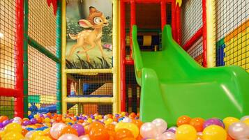 Un'area giochi per bambini con uno scivolo e una piscina di palline.
