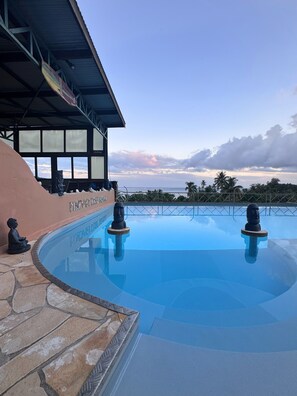 Alberca al aire libre, sombrillas en la alberca y camastros 