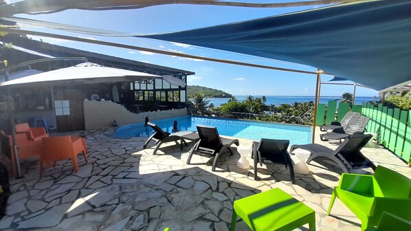 Alberca al aire libre, sombrillas en la alberca y camastros 