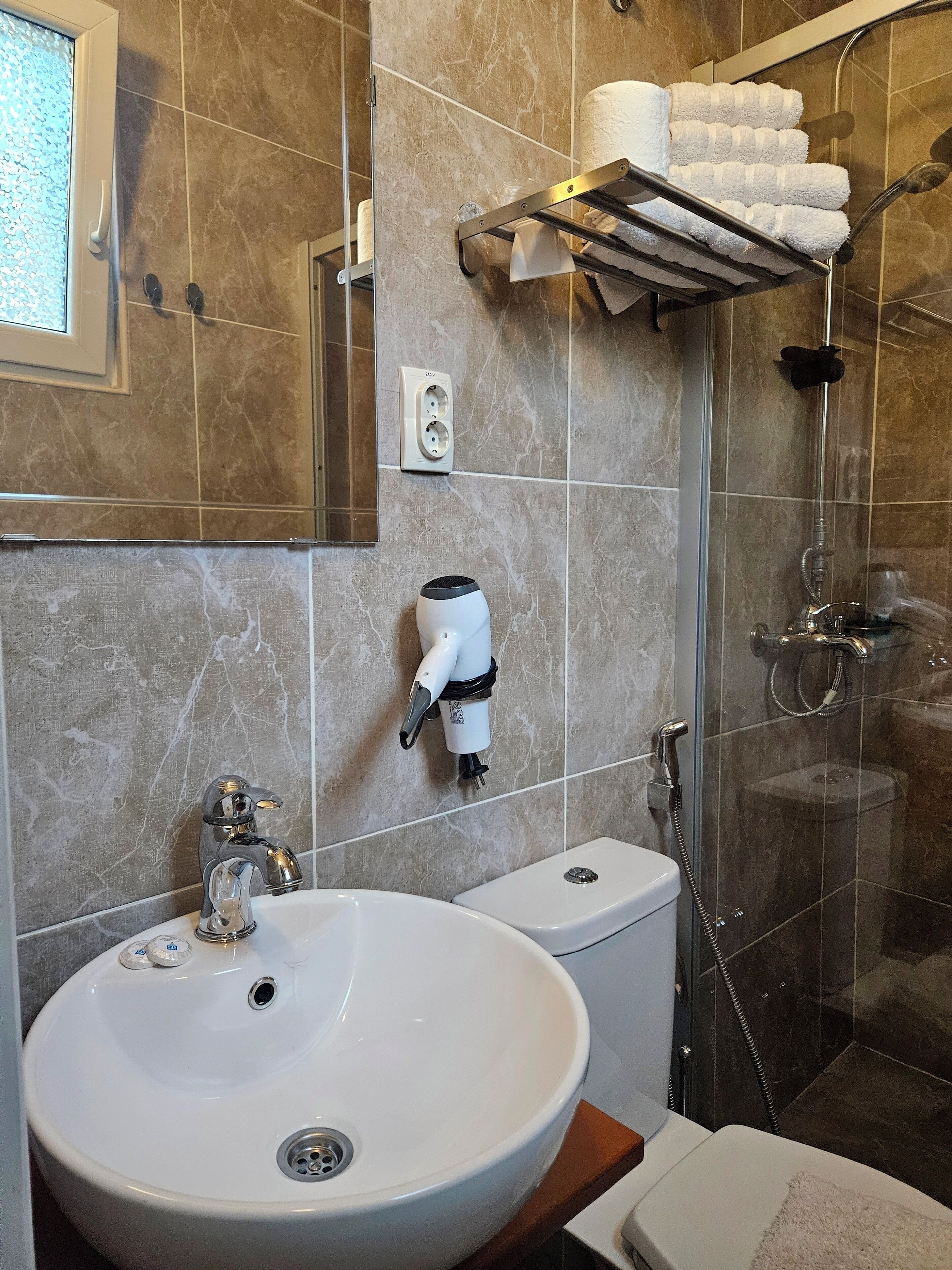 A bathroom with a sink, toilet, and shower.