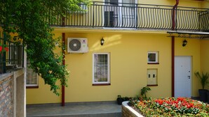 A yellow building with a balcony, a door, and a window. - Male stepenice (Belgrade)