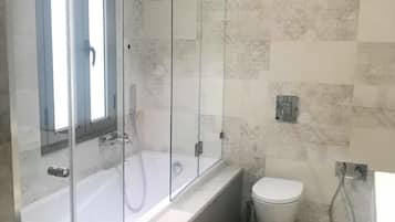 Un bagno moderno con doccia vetrata, vasca da bagno indipendente e servizi igienici.