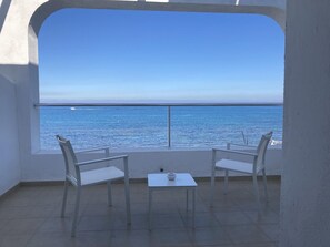 A balcony with two white chairs and a small table, overlooking a calm sea with a clear sky. - Dar Corniche La Marsa - Adults Only (La Marsa)