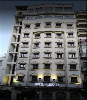 Um hotel de vários andares com design arquitetônico clássico, apresentando uma placa grande com a inscrição 