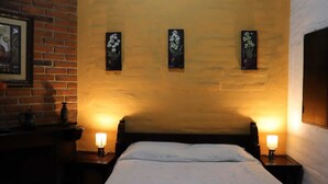 A room with a bed, two bedside lamps, and three wall-mounted paintings. - Hotel Villa Santo Domingo (Concepcion de Ataco)
