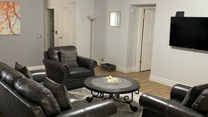 A living room with a ceiling fan, a flat-screen TV mounted on the wall, and a fireplace. - Downtown PHX -Private Home/Fam. Friendly/4 Blocks/Convention Center/Chase Field (Phoenix)