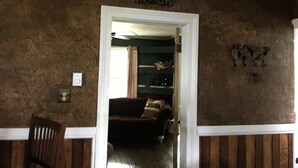 A room with a brown textured wall, a white door, a brown sofa, and a small table.