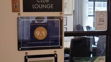 A wall with signs indicating the Dolce Kitchen Club Lounge, a 9.1 rating from Traveller Review Awards 2020, and a 9.4 rating from Hotels.com.