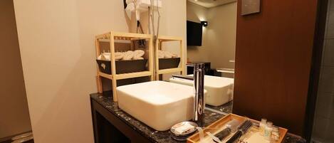 A bathroom with a large sink, a mirror, and a towel rack.