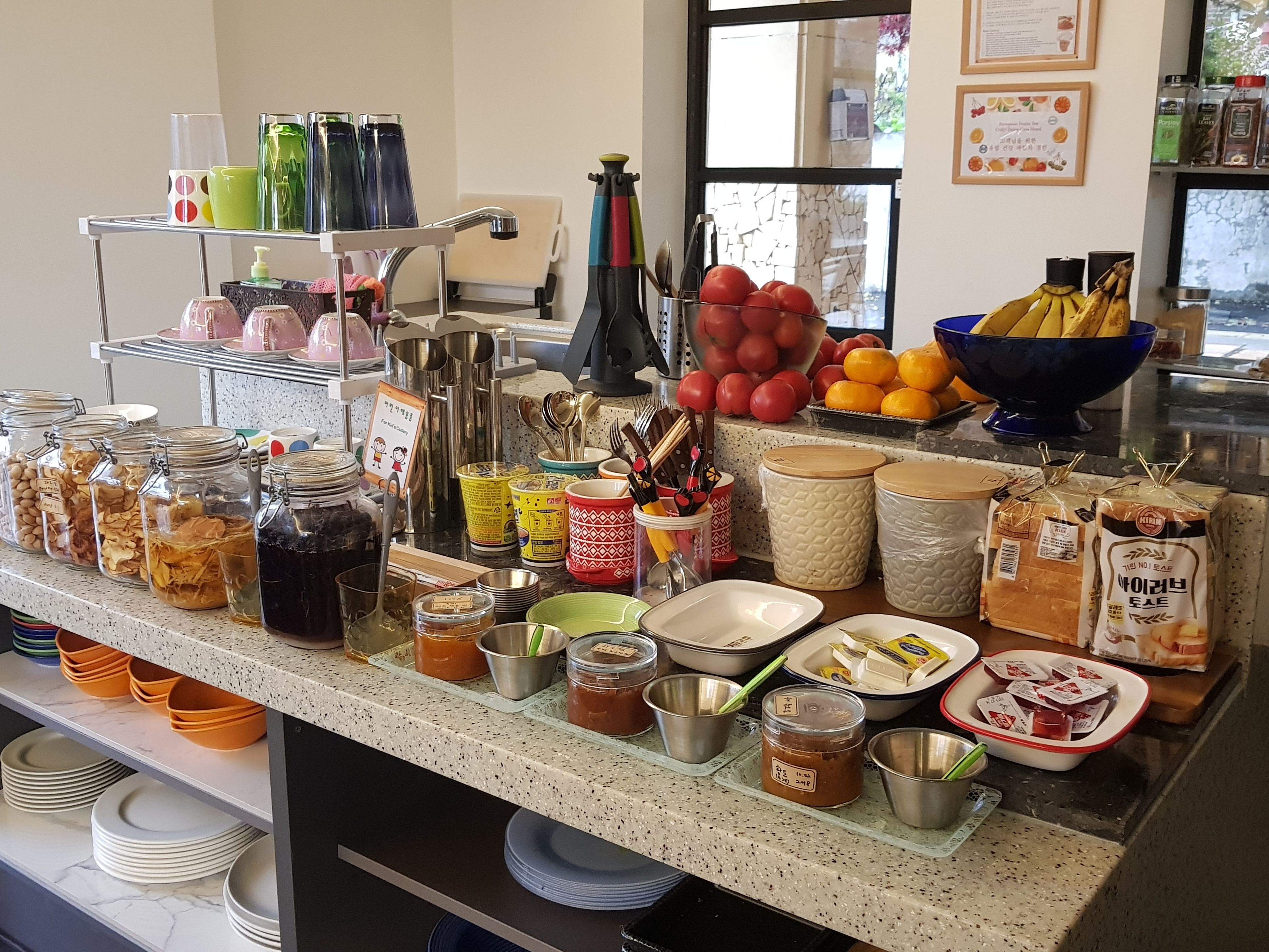 A well-stocked kitchen counter with various food items, utensils, and containers.