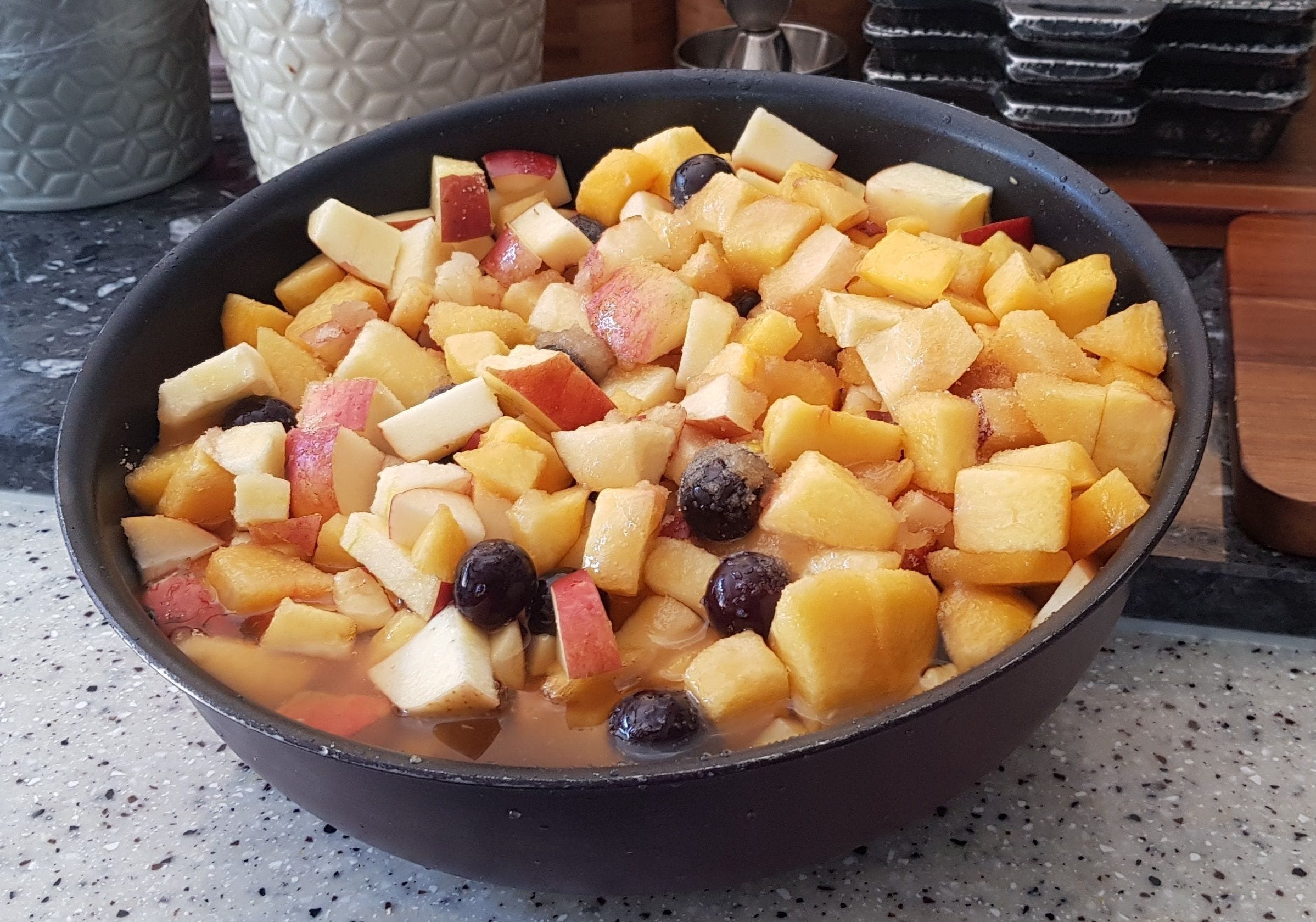 A bowl of fruit salad with various fruits and a liquid base.