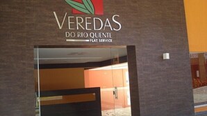 Ein moderner Gebäudeeingang mit einem Logo und der Aufschrift 'VEREDAS DO RIO QUENTE'.